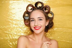 schön Mädchen im Haar Lockenwickler isoliert auf Gold foto