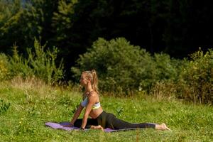 Fitness Frau Sitzung im ein Yoga Pose im ein Park. foto