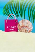 Rosa Paket mit ich Liebe Sie und Muschel Schale auf Sand von Strand mit Palme Baum, Meer. Valentinstag Tag, Geburtstag, März 8., Verkauf. Kopieren Raum foto