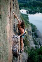 ein Mädchen klettert ein Felsen. Frau beschäftigt, verlobt im extrem Sport. foto