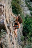 ein Mädchen klettert ein Felsen. Frau beschäftigt, verlobt im extrem Sport. foto