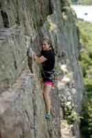 ein Mädchen klettert ein Felsen. Frau beschäftigt, verlobt im extrem Sport. foto