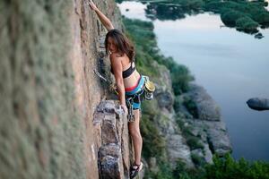 ein Mädchen klettert ein Felsen. Frau beschäftigt, verlobt im extrem Sport. foto