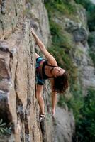 ein Mädchen klettert ein Felsen. Frau beschäftigt, verlobt im extrem Sport. foto