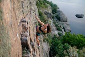 ein Mädchen klettert ein Felsen. Frau beschäftigt, verlobt im extrem Sport. foto