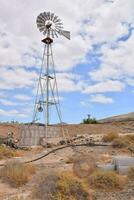 ein alt Windmühle im das Wüste mit ein Blau Himmel foto