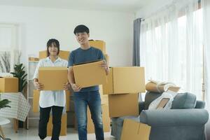asiatisch jung glücklich Neu verheiratet Paar ziehen um zu ihr Neu Haus oder echt Anwesen. foto