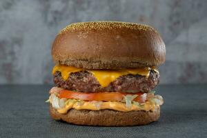 Käse Burger - - amerikanisch Käse Burger mit frisch Salat auf dunkel Hintergrund foto