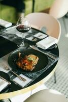 gebacken Schweinefleisch Rippen auf das Tabelle mit ein Glas von rot Wein foto