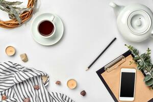 Notizblock mit Stift und Tasse von Tee auf Weiß Tisch. Arbeiten Raum. handgefertigt. oben Sicht, eben legen. foto