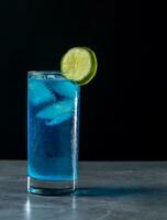 Blau hawaiisch Cocktail mit Limette und Eis auf ein schwarz Hintergrund. foto