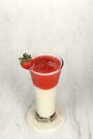 Erdbeere Saft mit Eis Sahne ist serviert im ein sehr luxuriös klar Glas. isoliert im Weiß und dunkel Hintergrund foto