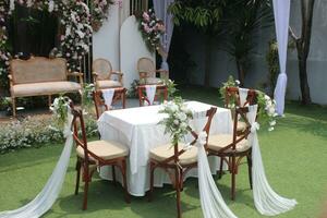 Hochzeit Altar und Reihe von braun und Weiß Stühle Schuss beim niedrig Winkel bereit auf das schön Park oder Garten foto