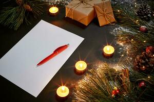 Weihnachten Spielzeuge, Verbrennung Kerzen und Notizbuch Lügen in der Nähe von Grün Fichte Ast auf schwarz Hintergrund oben Sicht. Raum zum Text foto