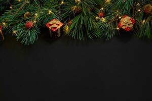 Weihnachten. Weihnachten Spielzeuge und Fichte Ast auf schwarz Hintergrund oben Sicht. Raum zum Text foto