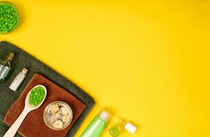 Spa oder Wellness Rahmen im Grün Farben. Flaschen mit wesentlich Aroma Öl, Handtücher, Meer Salz- auf Gelb Hintergrund. foto