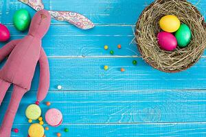 bunt Ostern Ei im Nest auf Blau Holz Tafel. foto