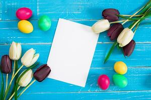 bunt Ostern Eier und Tulpen auf Blau rustikal hölzern Hintergrund foto