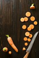 geschnitten Karotte auf Schiefer und hölzern Zähler oben Hintergrund foto