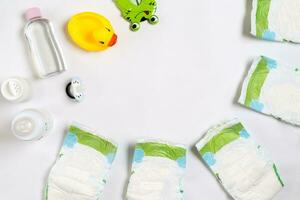 Babys Waren Windel, Baby Pulver, Creme, Shampoo, Öl auf Weiß Hintergrund mit Kopieren Raum. oben Aussicht oder eben legen. foto