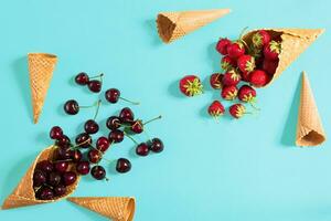 Beeren im Waffel Zapfen - - Erdbeere und schwarz Kirsche auf Blau ba foto