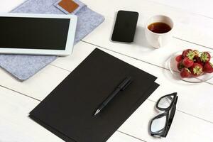 modern Arbeitsplatz mit Digital Tablette Computer und Handy, Mobiltelefon Telefon, Tasse von Kaffee, Stift und leeren Blatt von Papier. foto