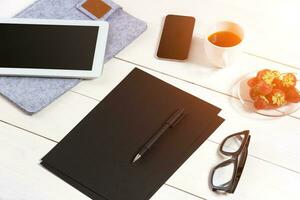 modern Arbeitsplatz mit Digital Tablette Computer und Handy, Mobiltelefon Telefon, Tasse von Kaffee, Stift und leeren Blatt von Papier. foto