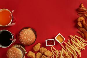 Burger und Chips. Hamburger und Französisch Fritten im rot Papier Kasten. schnell Essen auf rot Hintergrund. foto