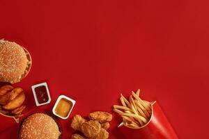 Burger und Chips. Hamburger und Französisch Fritten im rot Papier Kasten. schnell Essen auf rot Hintergrund. foto