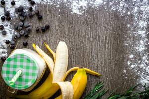 Banane Smoothie und frisch Banane auf hölzern Tisch. foto