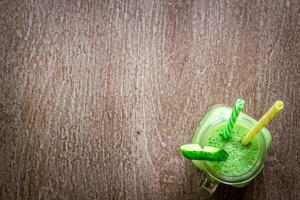 Glas von Spinat Saft auf hölzern Hintergrund foto