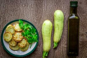 Zucchini, gebraten im Teig auf Gericht auf ein hölzern Hintergrund. foto