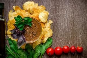 Kartoffel Chips mit Eintauchen Soße auf ein hölzern Tisch. ungesund Essen auf ein hölzern Hintergrund. foto