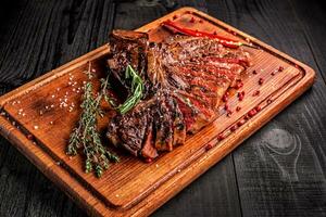 geschnitten Mittel Selten gegrillt Steak auf rustikal Schneiden Tafel mit Rosmarin und Gewürze , dunkel rustikal hölzern Hintergrund, oben Aussicht foto