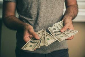ein Mann hält Dollar im seine Hände foto