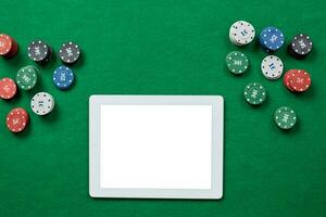 online Poker Spiel mit Digital Tablette und Stapel von Chips. foto