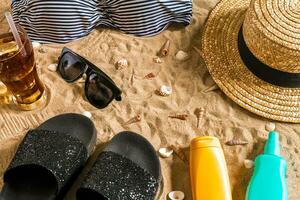 Sommer- Bikini und Zubehör stilvoll Strand Satz, Strand Bikini Sommer- Outfit und Meer Sand wie Hintergrund, oben Sicht, Konzept foto