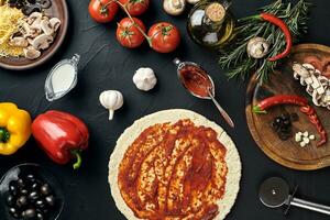 roh Pizza Zutaten auf schwarz Textur Tabelle Hintergrund foto
