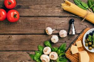 Italienisch Essen Hintergrund mit Pasta, Gewürze und Gemüse. oben Sicht, Kopieren Raum. foto