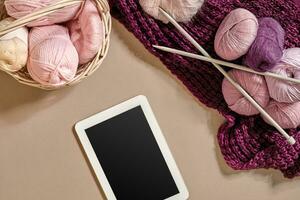 Rosa und lila Bälle von wolle Fäden mit Stricken Nadeln Lügen im Korb auf Beige Hintergrund. spotten oben Hintergrund zum Ihre Kunst Stricken foto