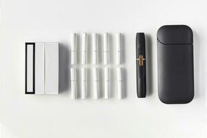 Neu Generation schwarz elektronisch Zigarette und Batterie, Pack und zehn Hitzestäbe isoliert auf Weiß. Neu Technologie. Heizung Tabak System. schließen oben foto