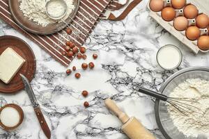 Nahansicht Schuss. oben Aussicht von ein Backen Zutaten und Geschirr auf das Marmor Tabelle Hintergrund. foto