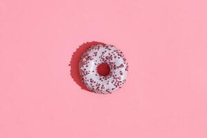 Essen Design. schließen oben hoch Qualität Bild von Rosa glasiert Krapfen auf Koralle Rosa Hintergrund foto