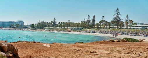 Panorama- Schuss von ein Strand mit Steine und transparent Wasser von das azurblau Mittelmeer Meer, umgeben durch ein malerisch Natur von Zypern. Ayia napa. foto