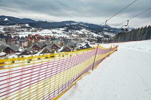 Panorama von Ski Erholungsort, Neigung, Menschen auf das Ski Aufzug, Skifahrer auf das Piste unter Grün Kiefer Bäume und Schnee Lanzen. foto