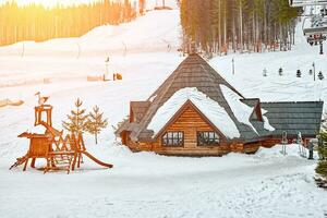 Winter Ferien Urlaub hölzern Haus im das Berge bedeckt mit Schnee und Blau Himmel. Sonne Fackel foto