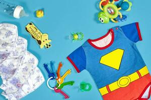 Baby Kleidung, Toilettenartikel, Spielzeuge und Gesundheit Pflege Zubehör auf Blau Hintergrund. foto
