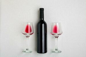 Overhead abgewinkelt Aussicht von ein groß Flasche von rot Wein, Trinken Brille auf Weiß Hintergrund foto