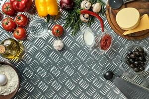 Essen Zutaten und Gewürze zum Kochen Pizza. Pilze, Tomaten, Käse, Zwiebel, Öl, Pfeffer, Salz, Ei, Reibe auf Metall Hintergrund. Kopieren Raum. oben Aussicht foto