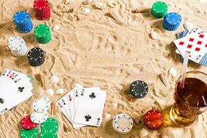 Glücksspiel auf Ferien Konzept - - Weiß Sand mit Muscheln , farbig Poker Chips und Karten. oben Aussicht foto